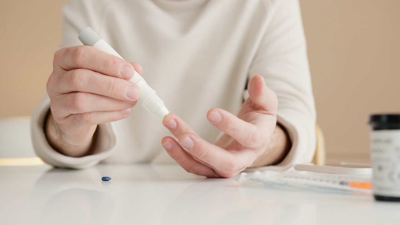 woman with diabetes pricking her finger for blood sample